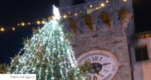Albero di Santa Fiora addobbato per Natale, sullo sfondo la torre dell'orologio