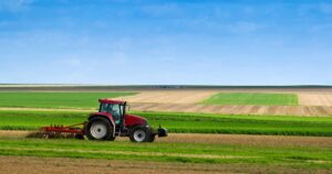 Un trattore al lavoro mentre coltiva campi