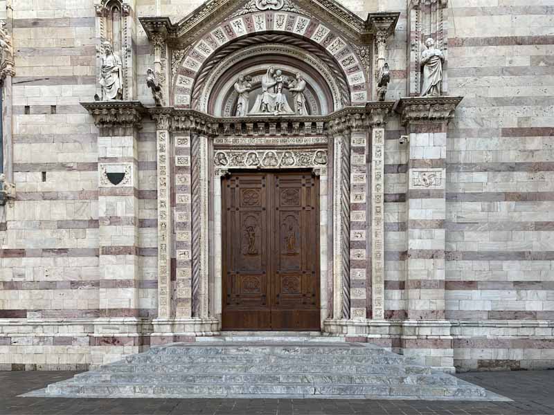 Il portone laterale del Duomo, a sinistra san Sebastiano e a destra san Cipriano