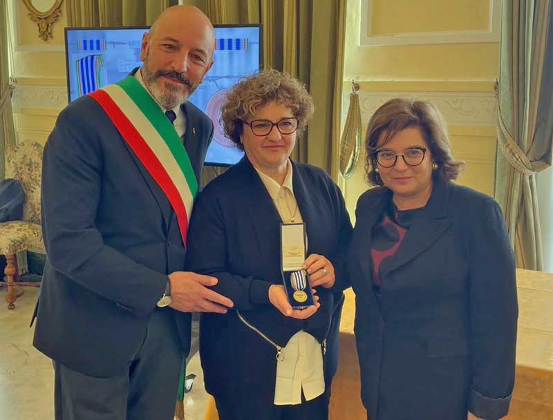 Il presidente del consiglio comunale Fausto Turbanti e la prefetta Paola Berardino consegnano la Medaglia d'Onore ad Anna Testa, figlia di Ermerindo