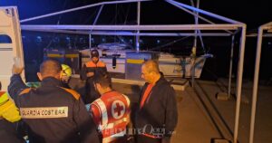 L'arrivo dell'anziano nuotatore a Cala Galera e i soccorsi, sullo sfondo la barca della scuola di vela Altura