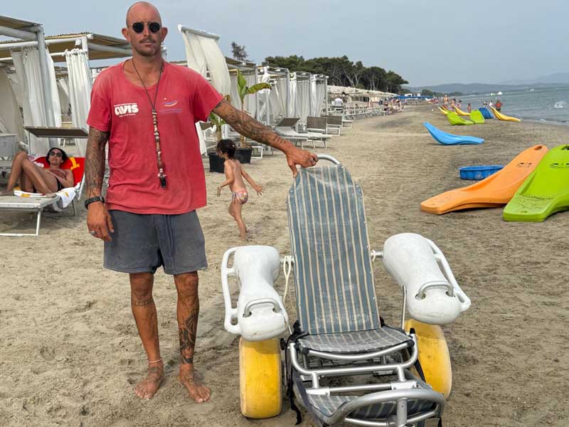 Un bagnino in Costa Est con una seggiola speciale per disabili