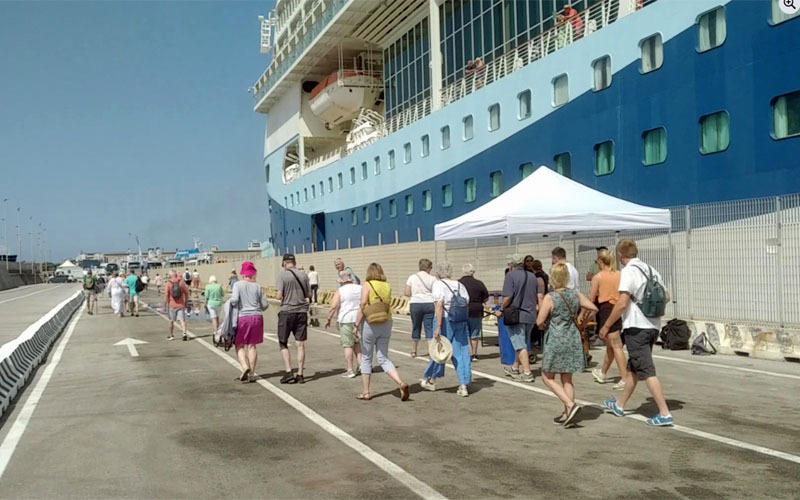 Turisti scendono da una nave da crociera nel porto di Piombino