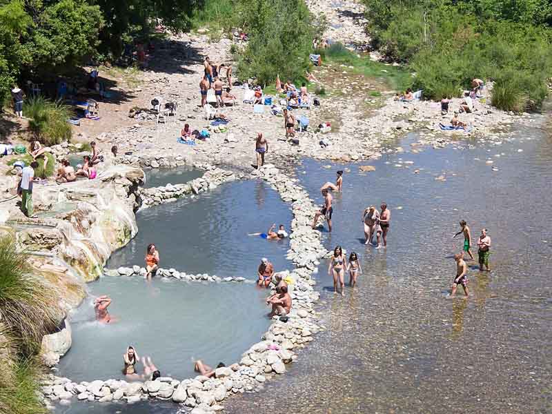 Turisti fanno il bagno alle Terme di Petriolo