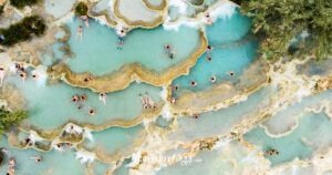 Turisti immersi nell'acqua termale alle cascatelle di Saturnia, in Maremma