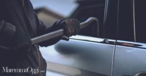 Un ladro che forza una portiera (foto d'archivio)