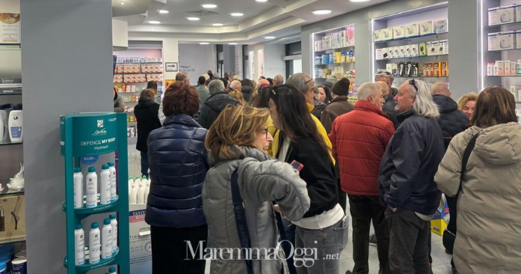 La coda di persone in attesa del cambio del medico nella farmacia Torelli di Luca Mencarelli