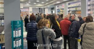 La coda di persone in attesa del cambio del medico nella farmacia Torelli di Luca Mencarelli