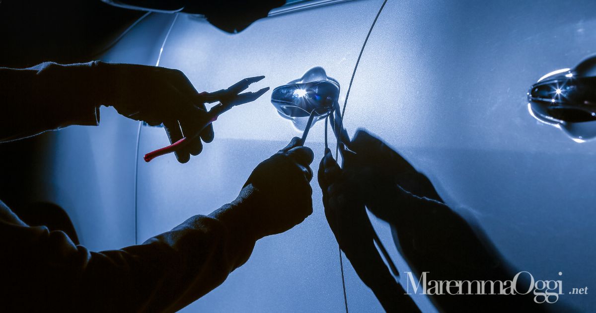 Un ladro mentre tenta un furto in un auto (foto d'archivio)