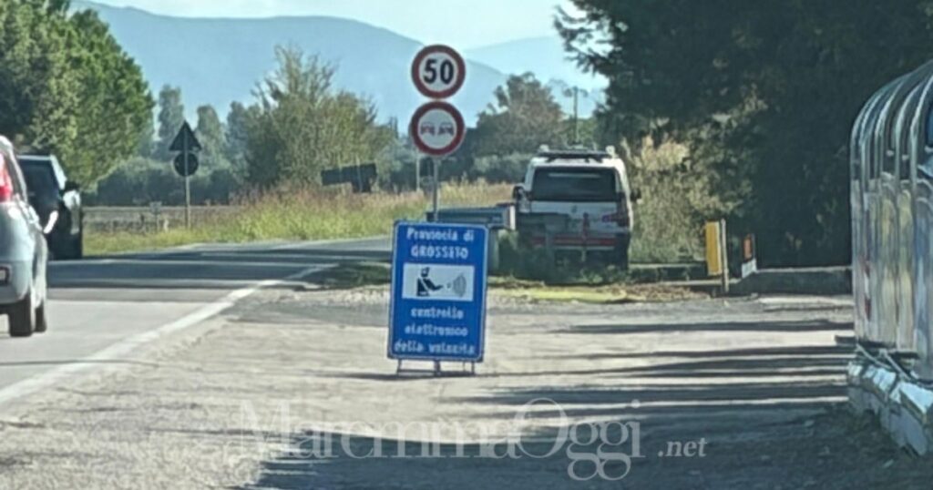 La macchina della polizia provinciale seminascosta nell'erba dietro al guard rail